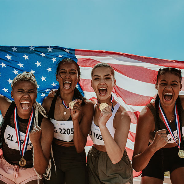 Photo of women holding American flag and medals
