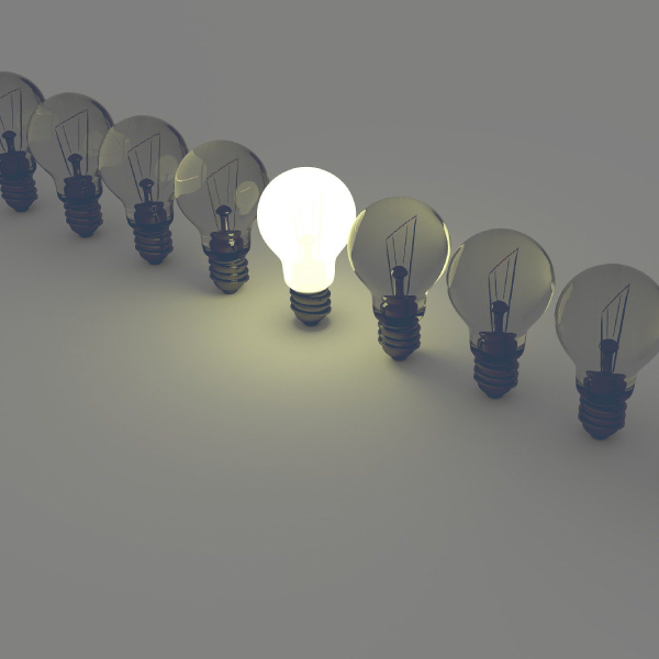 Photo of lightbulbs in a line, one light bulb is illuminated